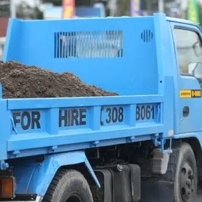 a blue tip truck with dirt in the back
